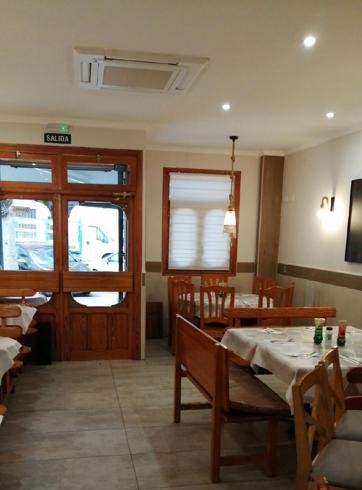 Salón de Manbys, con mesas y sillas de madera